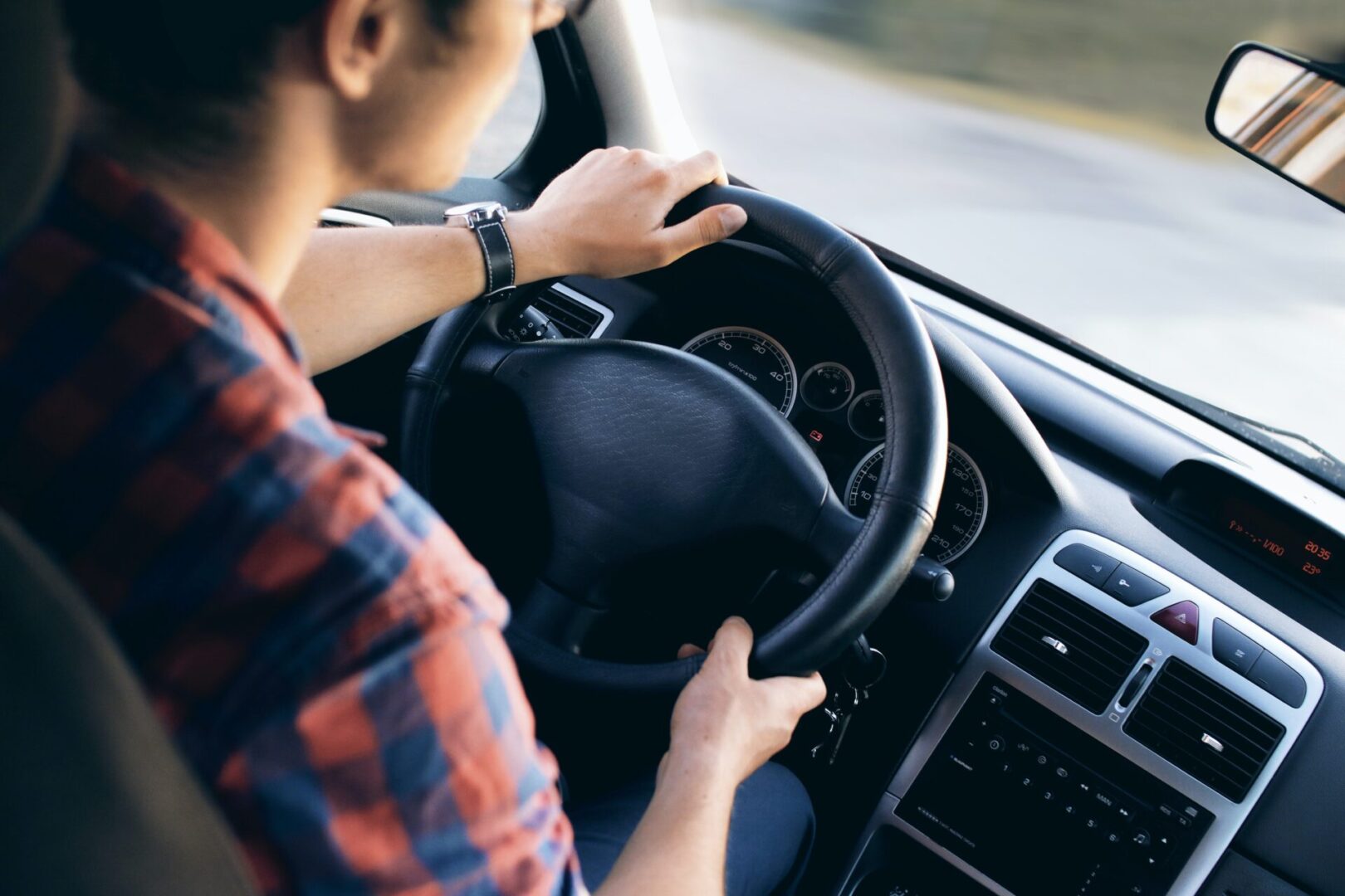 A person driving a car in the road.